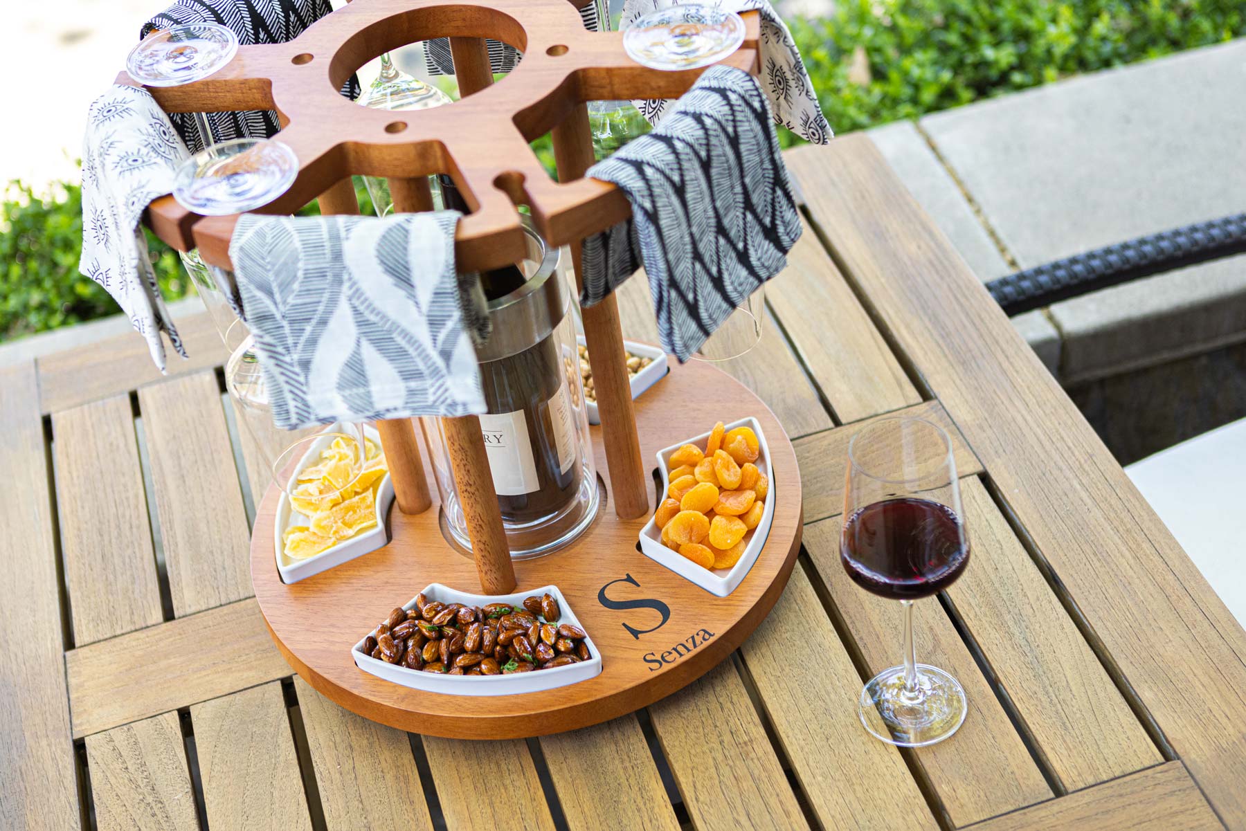 a wooden table topped with a plate of food and a glass of wine