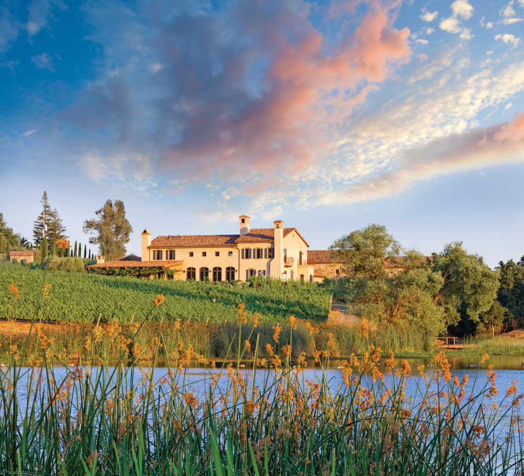 a large house sitting on top of a lush green hillside