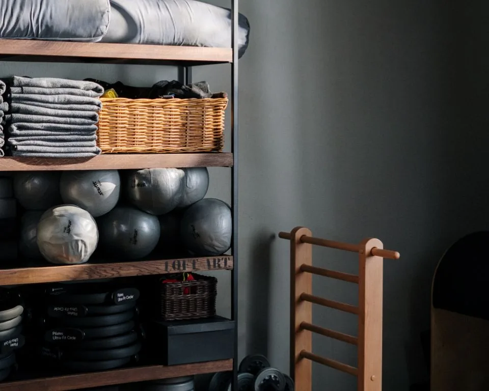 a wooden chair sitting next to a shelf filled with plates and bowls