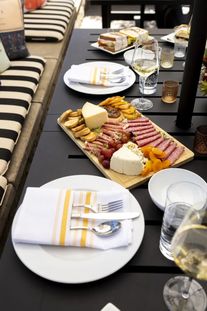 a table with plates of food and glasses of wine