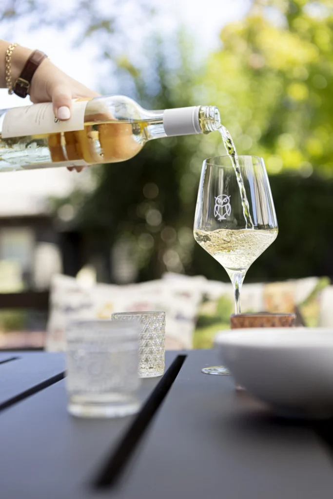 a person pouring wine into a wine glass