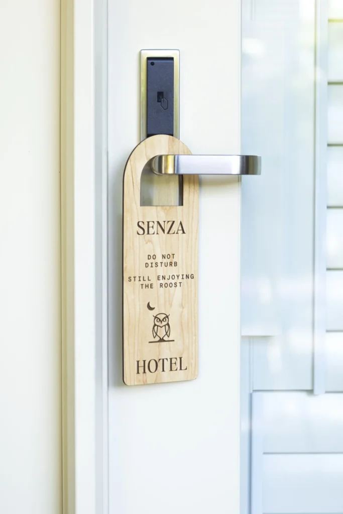 a wooden door handle with a hotel sign on it