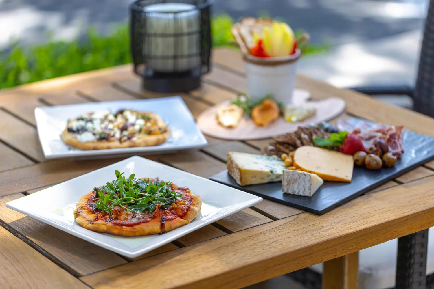 a wooden table topped with plates of food