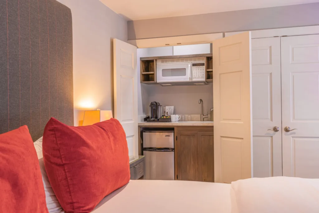 a bed with a red pillow and a microwave