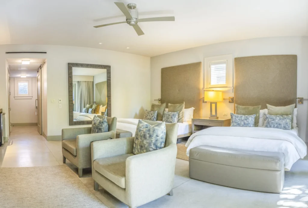 a bedroom with a bed, chairs and a mirror