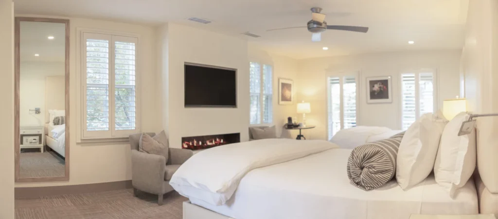 a bedroom with a large bed and a fireplace