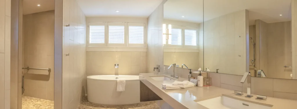 a bathroom with a tub, sink, and mirror