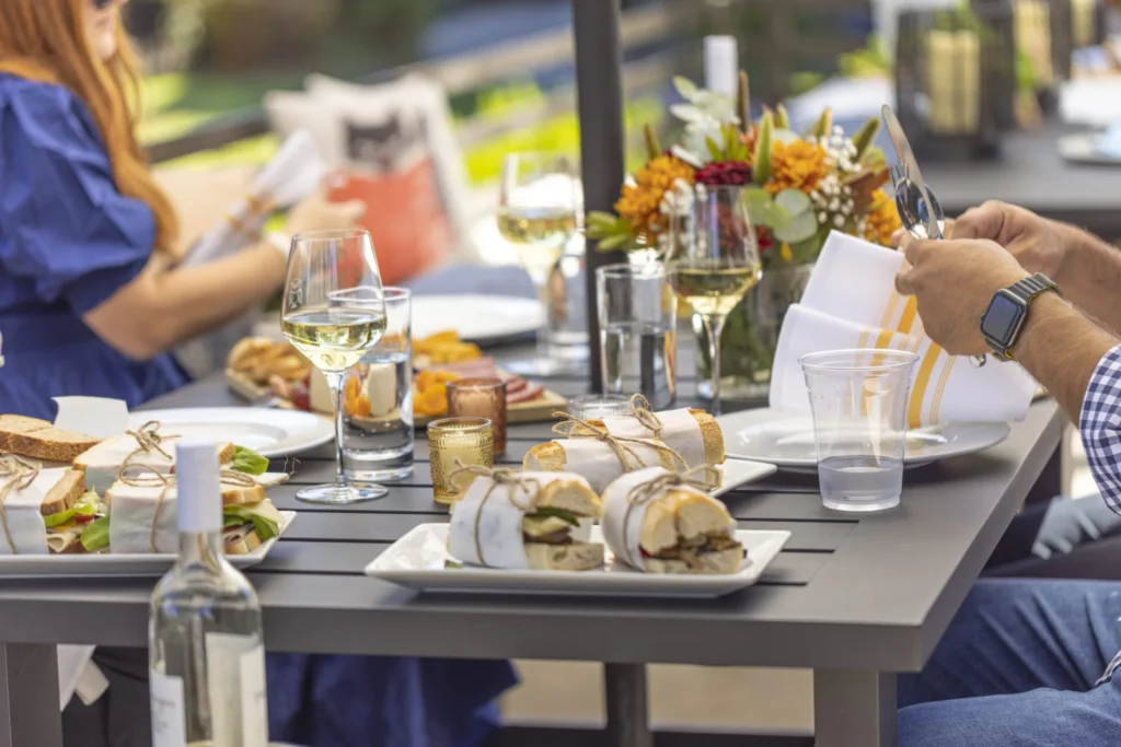 a group of people sitting at a table with plates of food