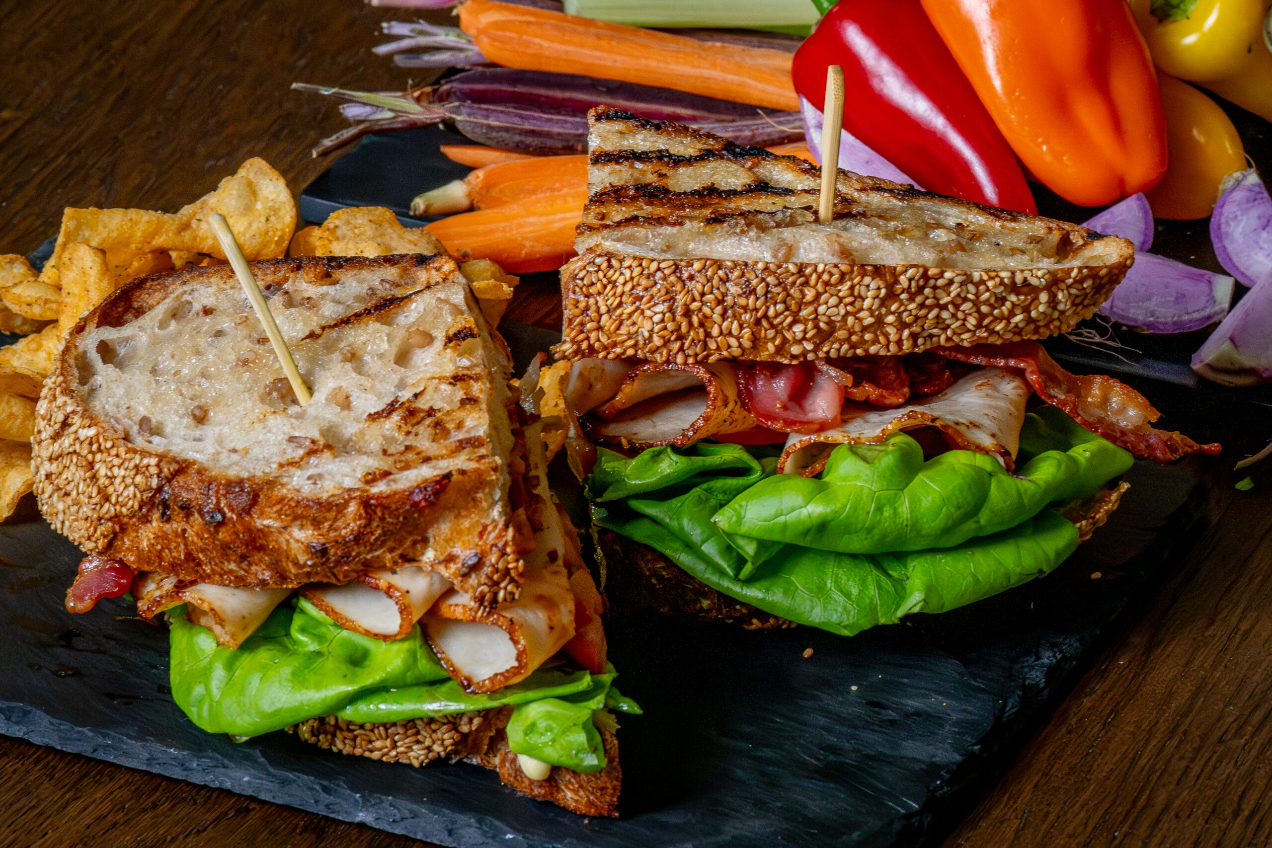Grilled turkey BLT sandwich with bacon, lettuce, and tomato served with chips at The Study restaurant at SENZA Hotel.