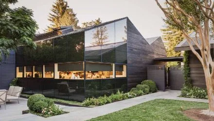 Modern dark wood and glass building exterior at Senza Hotel with landscaped garden