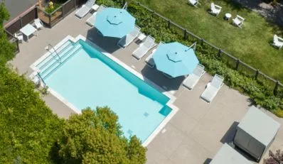 Aerial view of a hotel pool with lounge chairs and umbrellas
