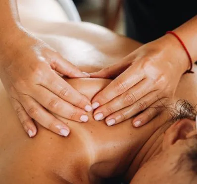 Therapist hands massaging a client's neck and shoulders