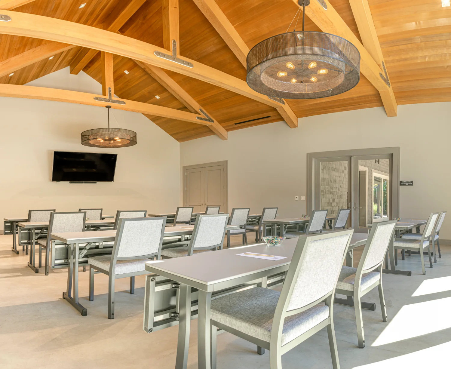 Modern conference room with wooden beam ceiling and classroom seating