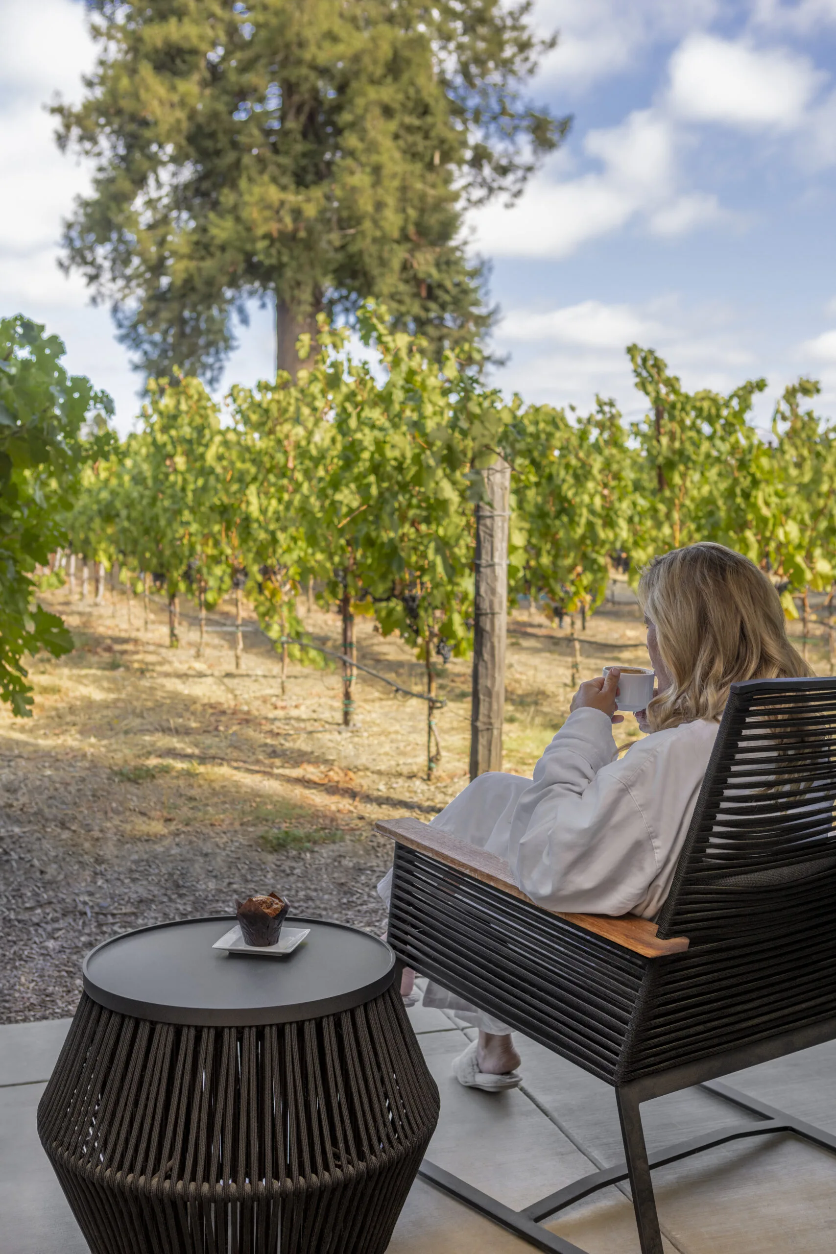 a woman sitting in a chair on a patio
