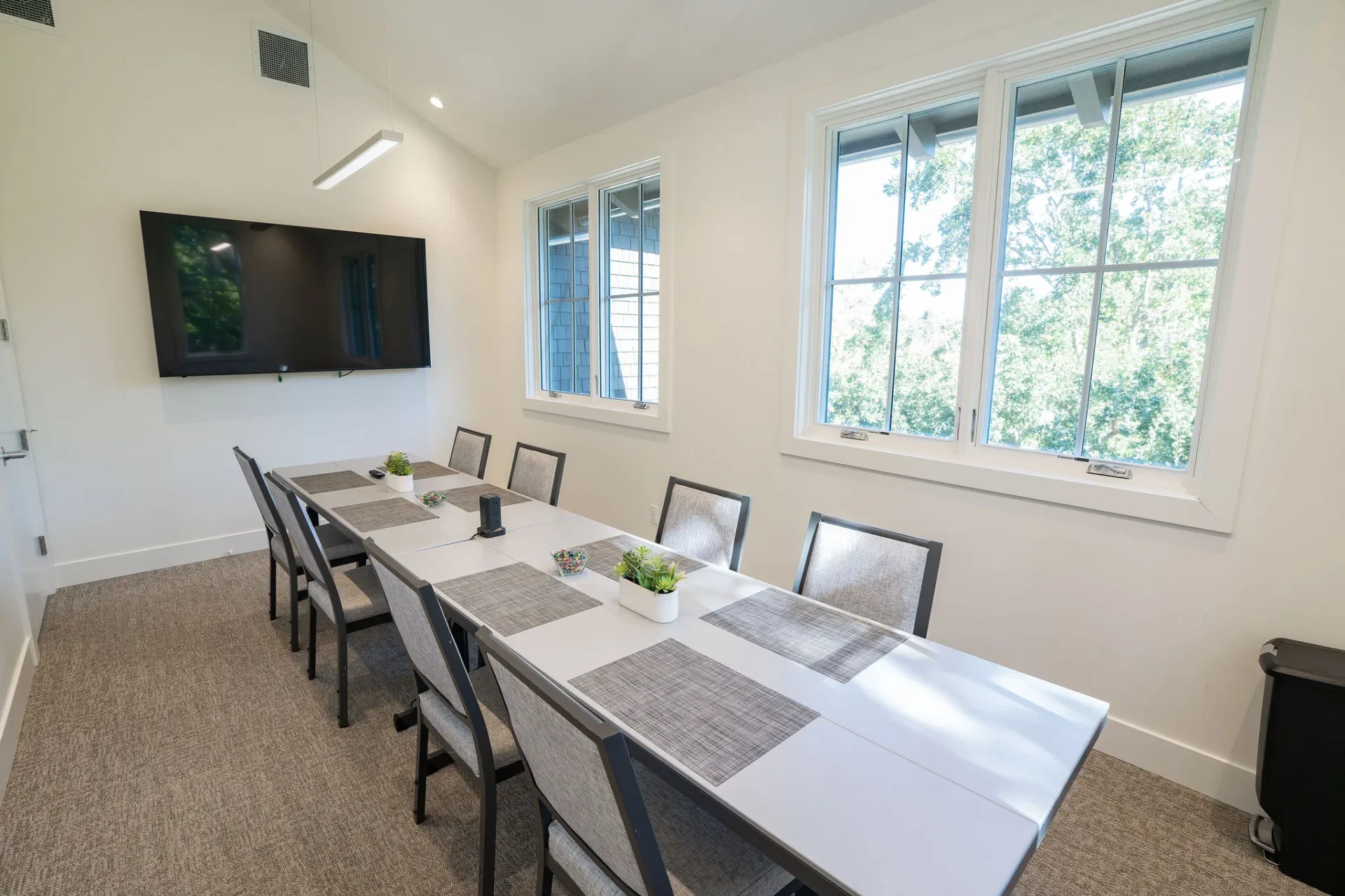 Modern conference room with long table and wall-mounted TV