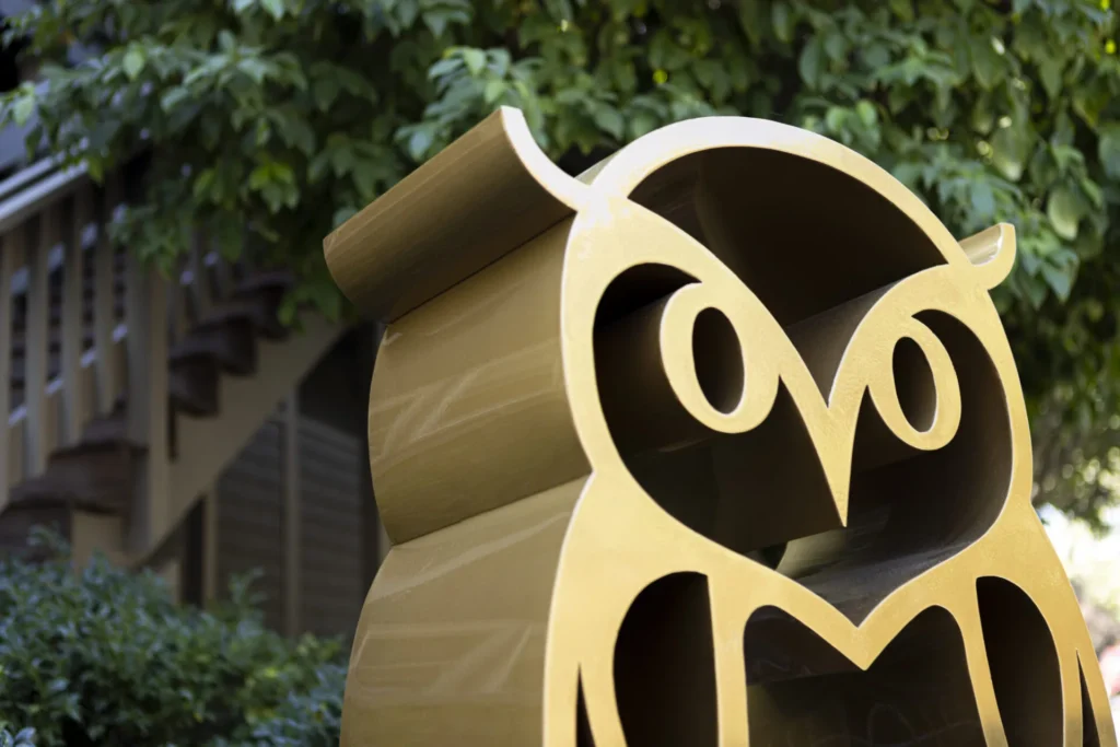 a close up of a sign with an owl on it