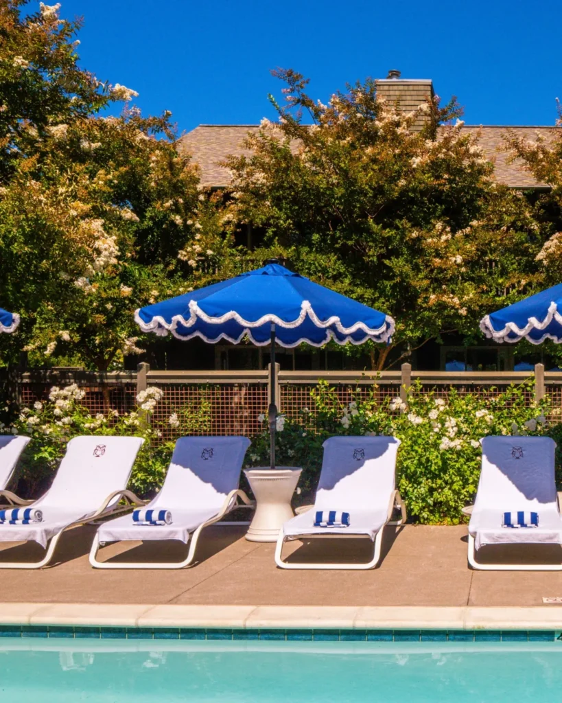 Poolside lounge chairs with blue umbrellas at Senza Hotel