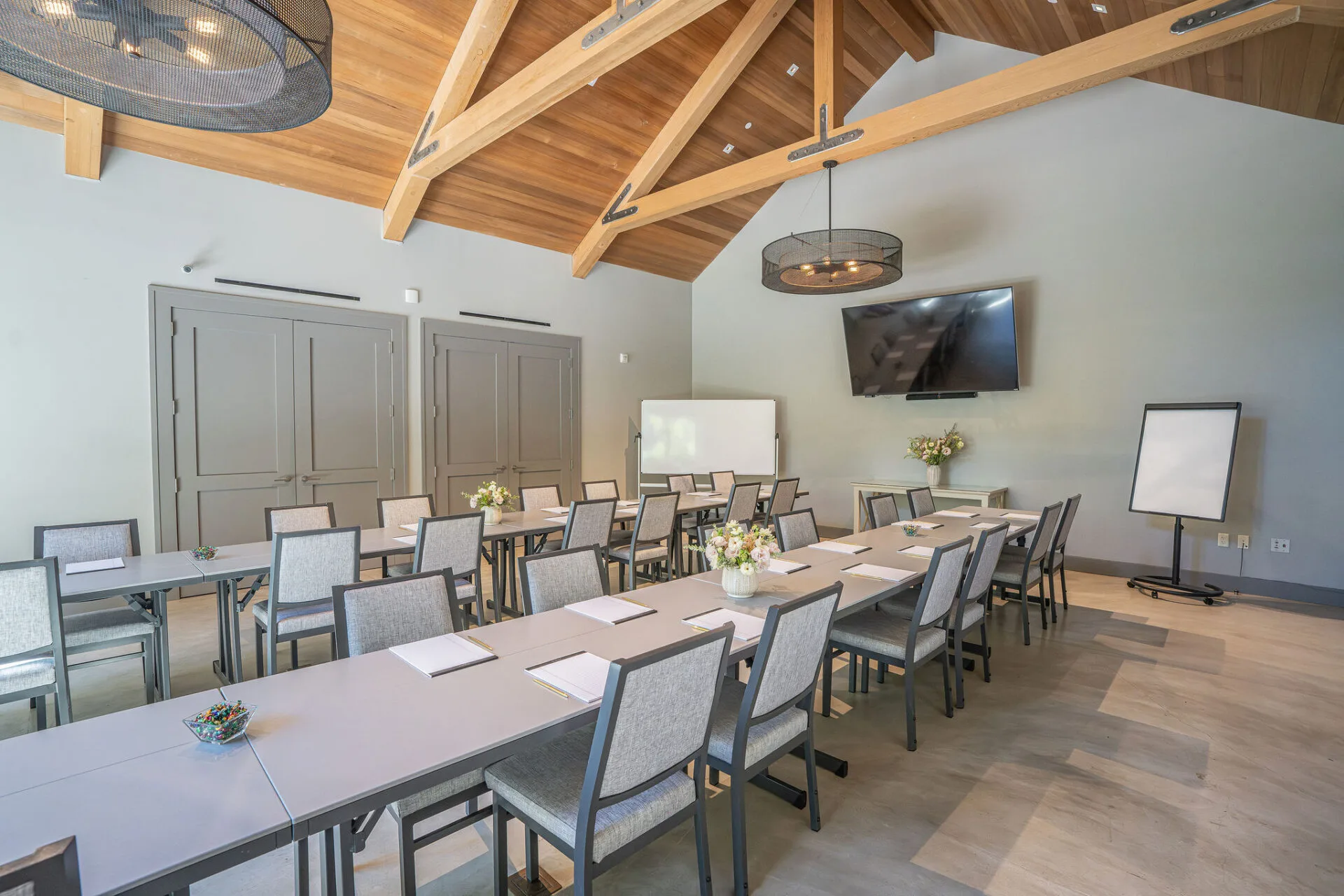 Modern conference room with wooden beam ceiling and classroom seating