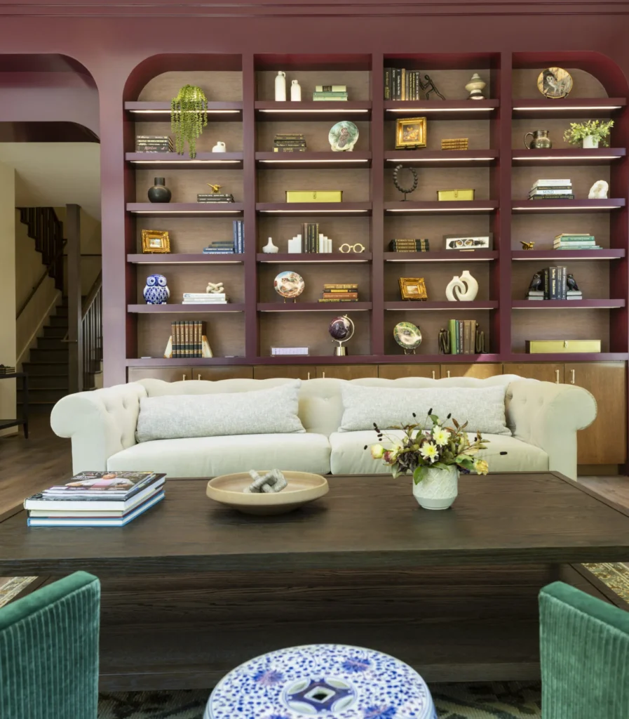 Elegant lounge area with a cream sofa and maroon bookshelves at Senza Hotel