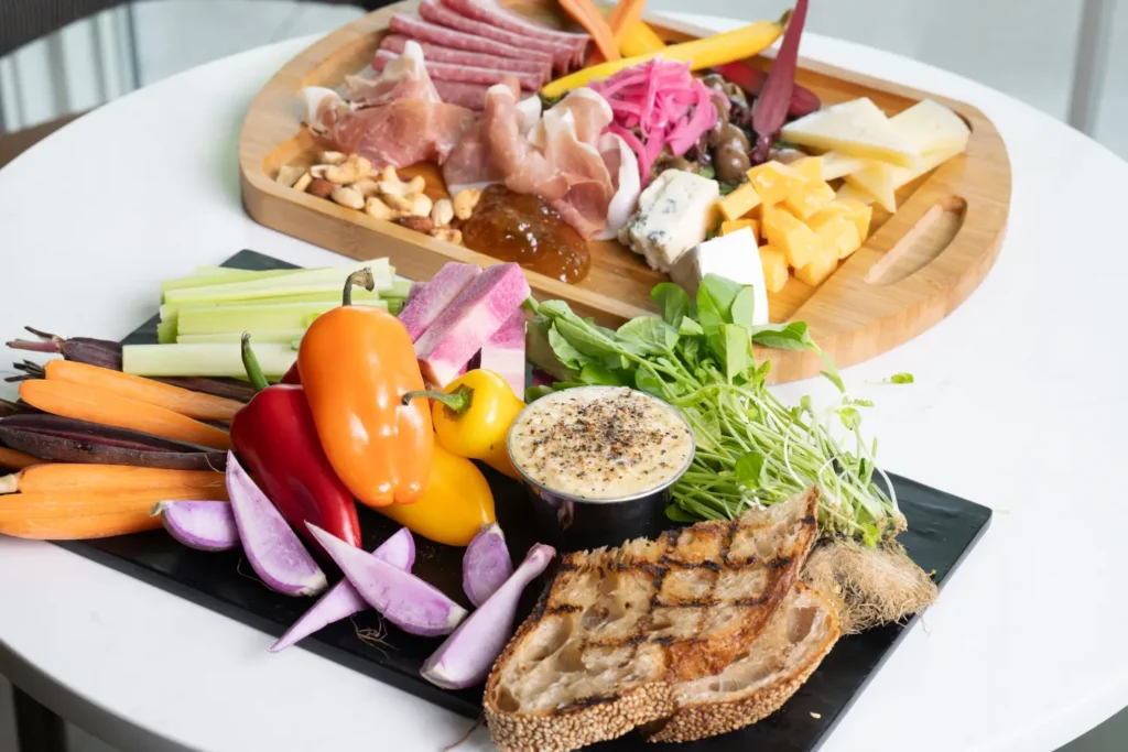 Colorful vegetable and cheese platters on a white table
