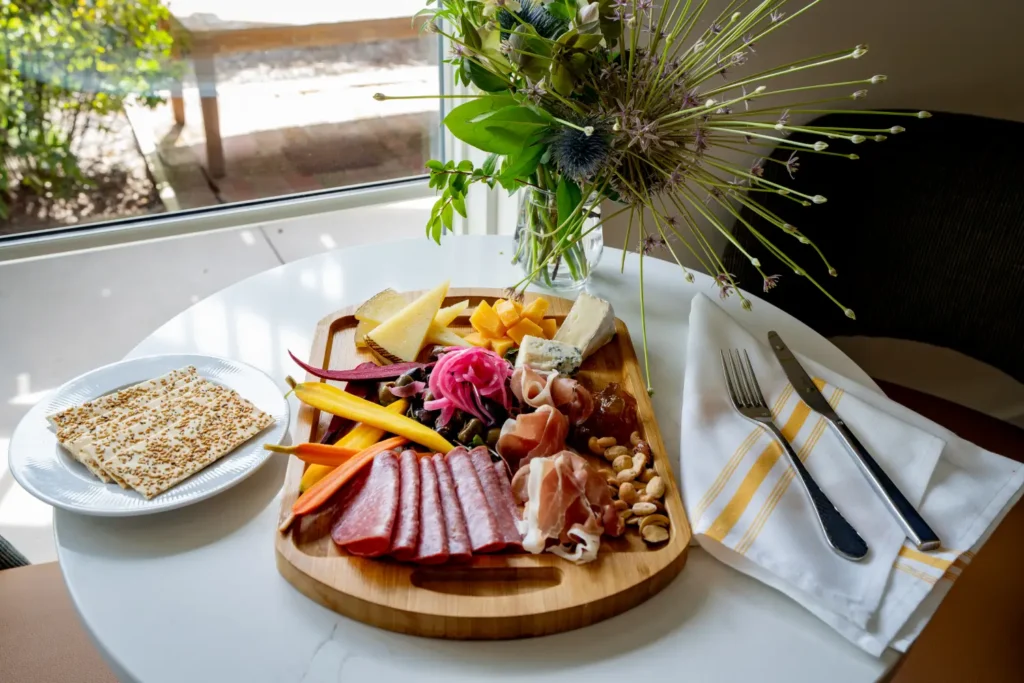 Elegant charcuterie board with meats, cheeses, and crackers on a hotel table