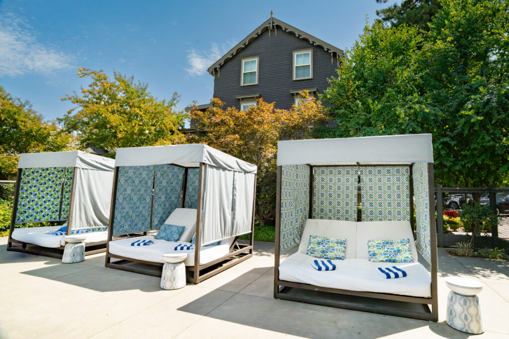 Outdoor cabanas with blue and white patterned curtains at Senza Hotel